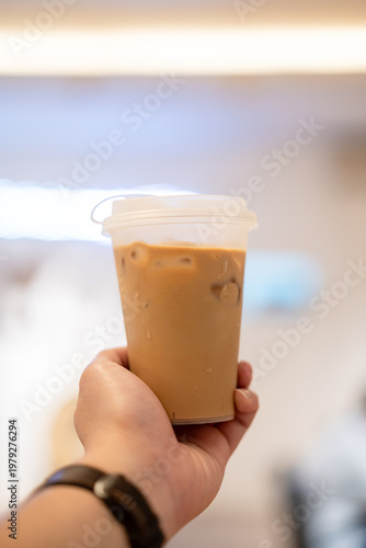 Hand holding cup of ice coffee