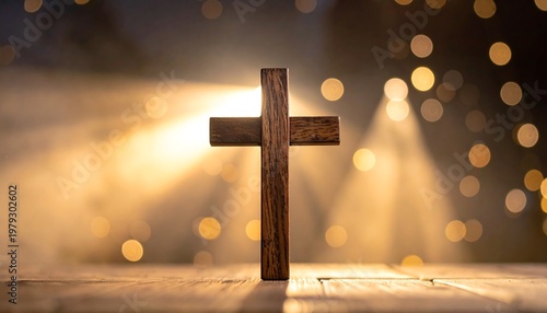 A wooden cross is illuminated against a golden bokeh backdrop, evoking spirituality and faith. Light rays emanate from behind