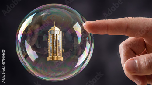 A finger reaching to touch a golden skyscraper inside a fragile iridescent soap bubble