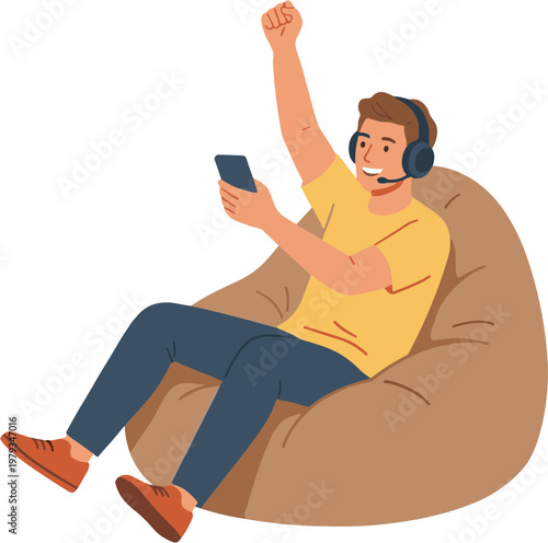 Man celebrating on bean bag with phone and headset on