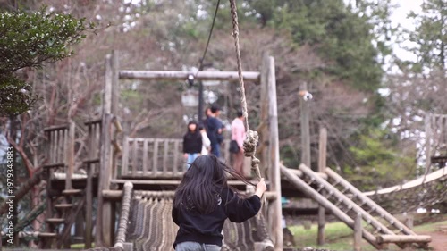 child, boy or girl starting a ride on a zip line at a forest playground, outdoor activity and fun for children.