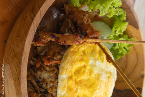 Authentic Indonesian Nasi Goreng fried rice with chicken satay and fried egg