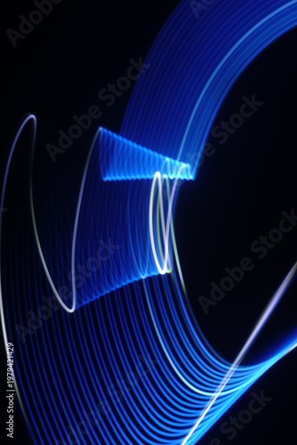 Electric blue light trails against a deep black background