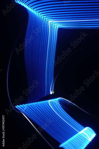 Electric blue light trails against a deep black background