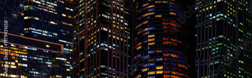 фотографія Multi-stories office building at night with worker working overtime