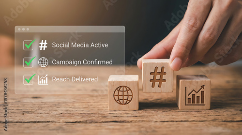 Hand positioning wooden blocks with social media hashtags and graphs on a rustic table for online campaign strategy