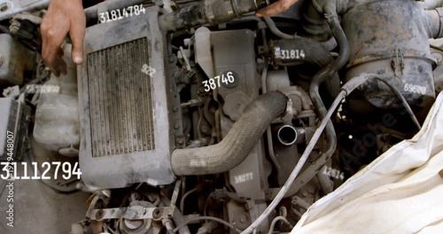 Inspecting engine block with corrugated intake hose and white cloth in garage, with bare forearm