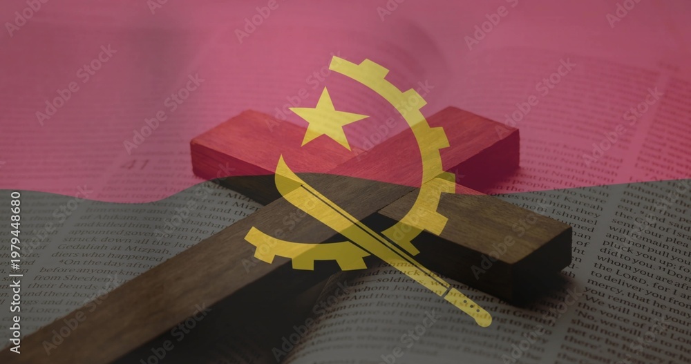 Fototapeta premium Lying wooden Christian cross casting soft shadow across open book on tabletop, Angola flag overlay