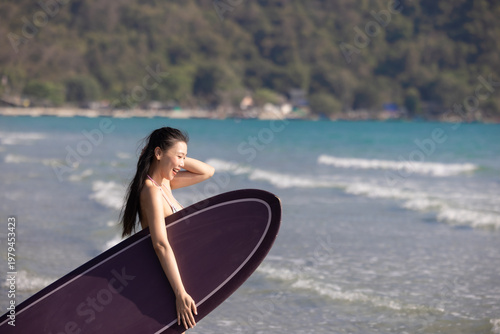 Photography Woman in a bright bikini surfing by the sea, enjoying fun and energetic ocean waves
