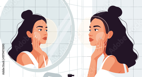 Beautiful young woman looking at her reflection in a round bathroom mirror while applying skincare products to her face at home.