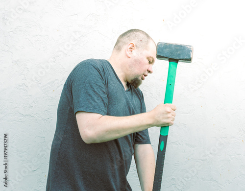 Wallpaper Mural Man grips heavy hammer, eyes closed, head bowed Torontodigital.ca