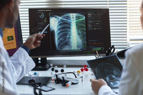 Quadro su tela Doctors reviewing chest x ray scan on monitor, discussing AI assisted diagnosis in medical office