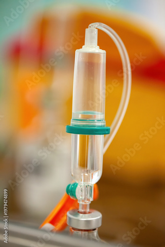 Close Up Of Intravenous IV Drip Chamber With Saline Solution