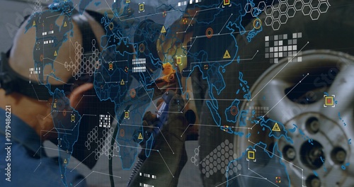 Grinding mechanic in blue coveralls, gloves, earmuffs, operating angle grinder on rim, sparks, HUD