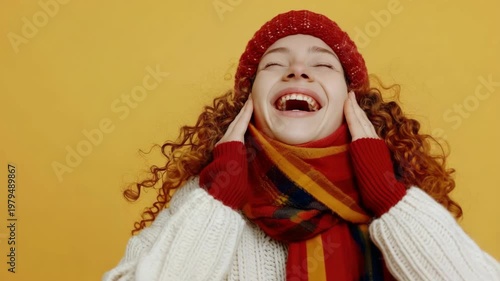 Curly-haired girl in scarf and hat smiling widely with joy