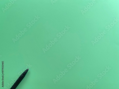 Minimal green background with pen and copy space, clean composition for writing, ideas and creative concepts