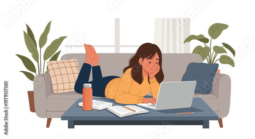 Young woman lying on a comfortable sofa at home working or studying on a laptop computer with books and notes on a coffee table.