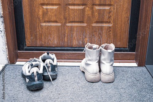 Foto Overhead of blank doormat with man and woman shoes on the porch at the front door