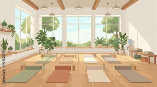 A bright and airy yoga studio is set up with mats, blocks, and water bottles, featuring large windows overlooking lush greenery and warm natural light.