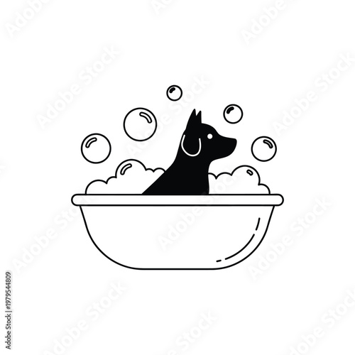 A black dog is sitting in a bathtub filled with bubbles and water