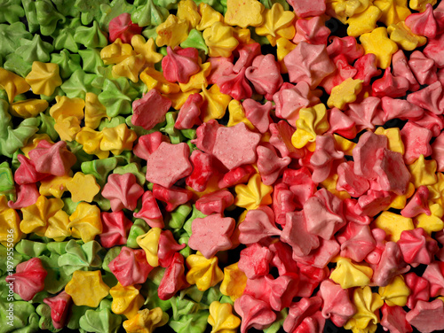 Colorful small star-shaped candies spread across a surface at a market during a festive event in spring