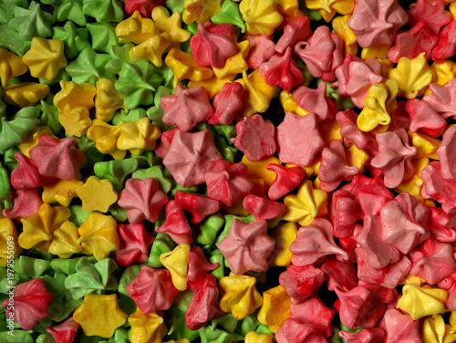 Colorful candy shapes fill a table at a market during daytime with various bright colors in view
