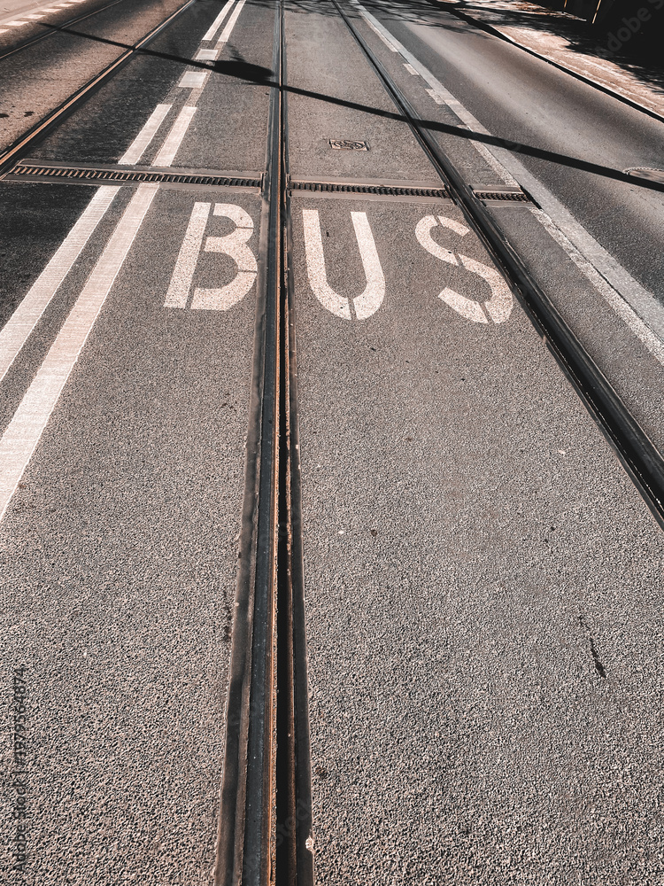 Fototapeta premium Tram tracks and bus lane marking on asphalt road, urban public transport infrastructure detail in city street