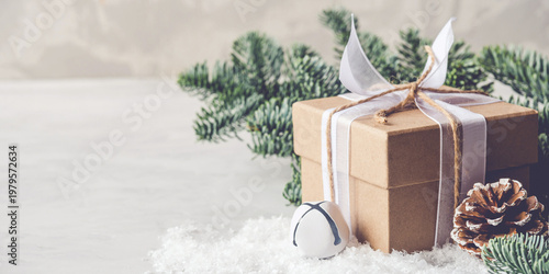 Christmas gift box in the snow on gray background. Christmas decor, winter mood, holiday decoration.