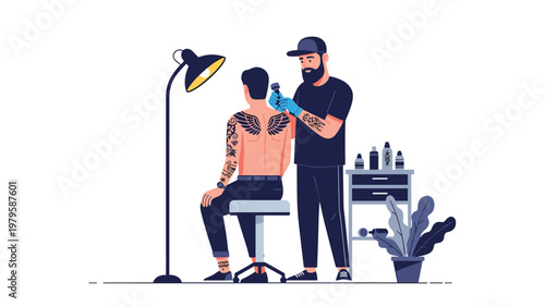 Professional tattoo artist wearing blue gloves and a cap working on a detailed wing tattoo on the back of a male client in a studio setting.