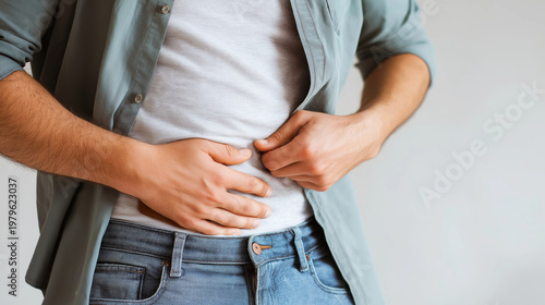 Man feeling discomfort, experiencing stomach pain, abdominal issues. Concept of gut health problems, diet, and nutrition concerns