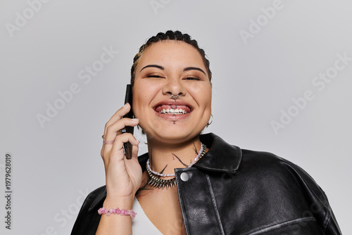 Принти на полотні Stylish young woman enjoying a cheerful phone call in modern attire