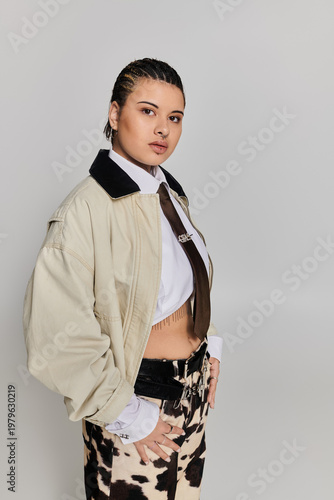 Stylish young woman poses confidently in chic outfit with modern flair during daytime indoors