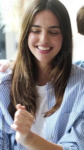 Joyful Young Woman Laughs and Smiles, Sharing a Happy Moment with a Companion Indoors