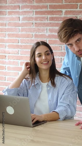Happy Young Professionals Collaborate on Laptop in a Bright Modern Workspace
