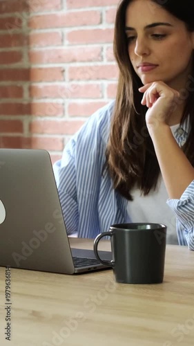 Focused Young Woman Working on Laptop and Enjoying Coffee