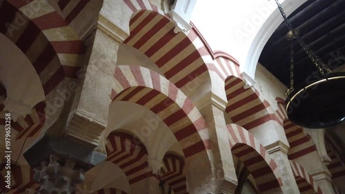 Symmetrical arches corridor in Cordoba mosque geometric perspective interior Spain