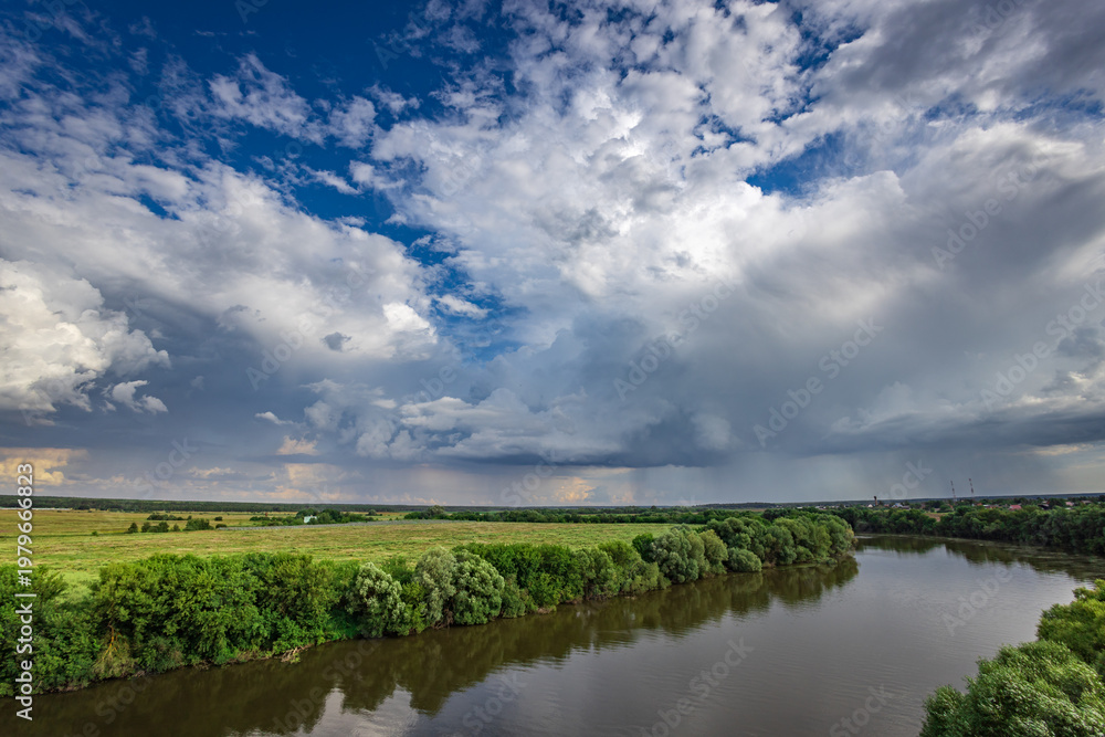 Fototapeta premium Serene river winds through lush green landscape