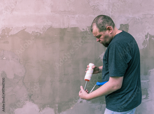 Wallpaper Mural Man focuses intently on painting a rough wall Torontodigital.ca