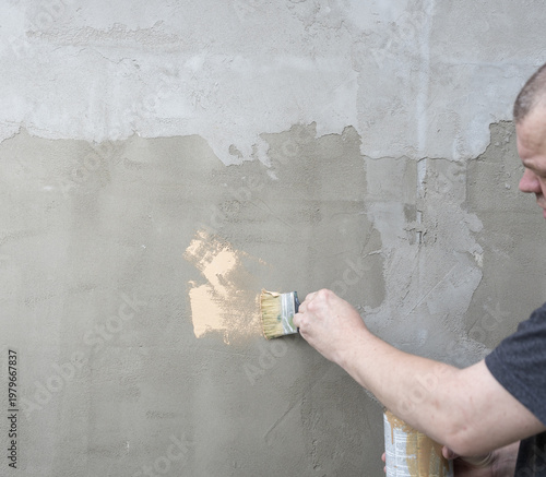 Wallpaper Mural Man applies plaster with brush to rough wall Torontodigital.ca