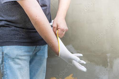 Wallpaper Mural Person puts on white work glove with yellow wristband Torontodigital.ca