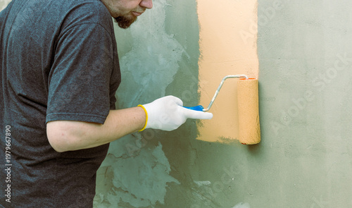 Wallpaper Mural Man paints wall with roller Torontodigital.ca