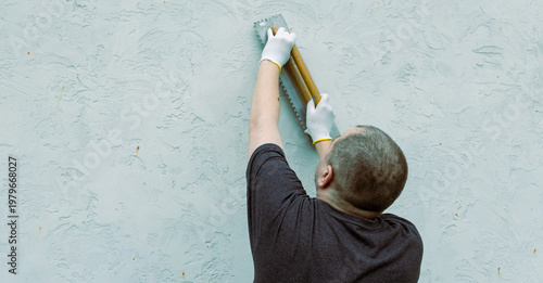 Wallpaper Mural Man applies plaster with a trowel on a textured wall Torontodigital.ca