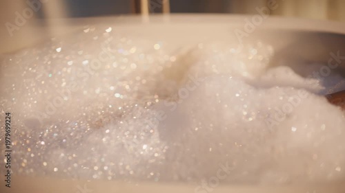 Feet bathing soap bubbles in luxury hotel closeup. Nude woman watching reels
