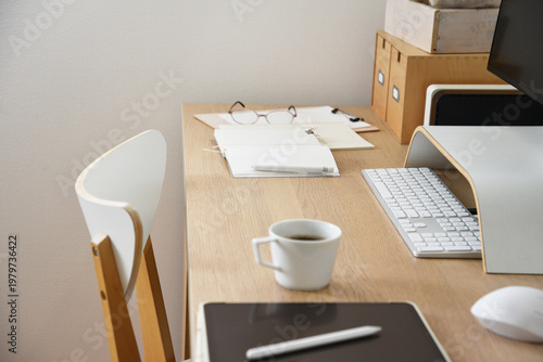 Minimal workspace with coffee cup computer and stationery on desk