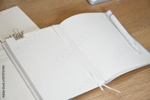 Open notebook with pen on wooden desk close up workspace scene