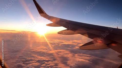 Airplane wing over clouds during golden hour sunrise or sunset