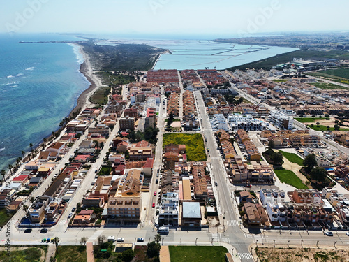 Aerial shot Lo Pagan cityscape with seafront promenade and salt flats lakes mud baths natural, open-air health spa, located on the northern edge of Mar Menor, in Murcia, Spain 