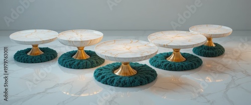 Elegant Display of White Cake Plates with Gold Accents on Teal Bases Set Against a Marble Background