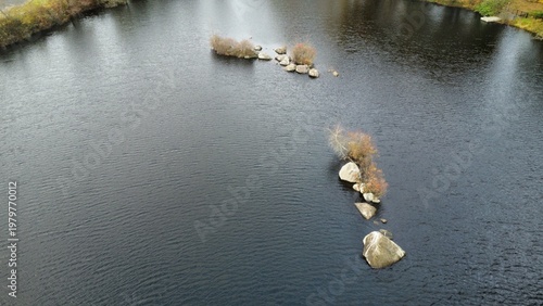 Aerial view of isolated rocks in a lake 