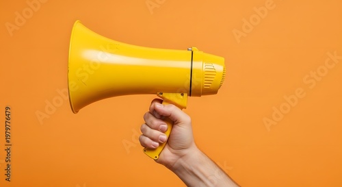 Hand Holding Yellow Megaphone for Marketing and Announcements on Bright Orange Background